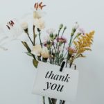 Vase with flowers in front of white background and thank you not attached